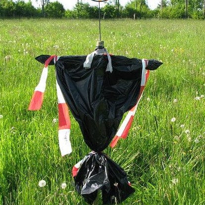 Eine Vogelscheuche aus einem Müllsack und rot-weißem Absperrband