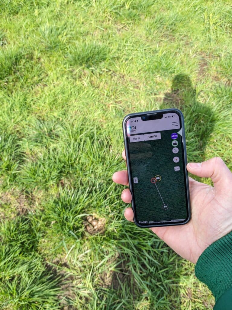 Smartphone mit POIApp und Nest im Hintergrund